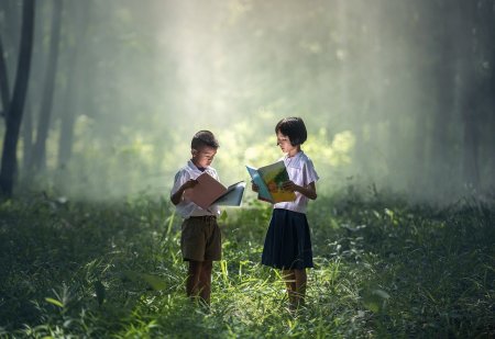 Children with books in woods and sunshine